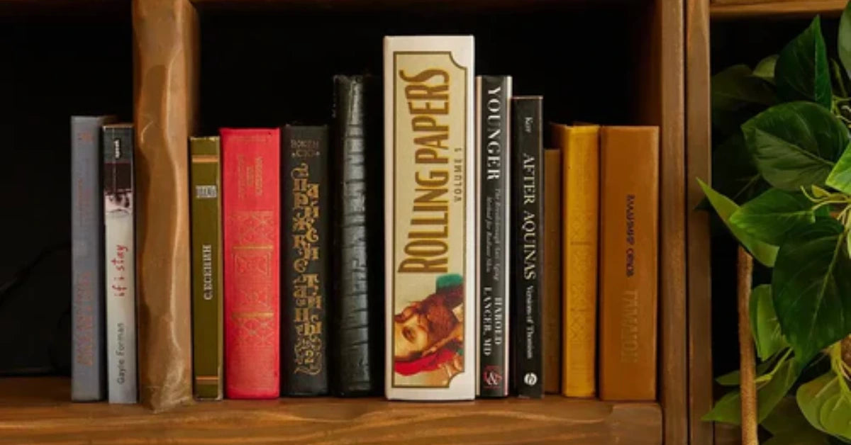 Zig-Zag Rolling Papers Volume 1 box positioned upright on a bookshelf among various books