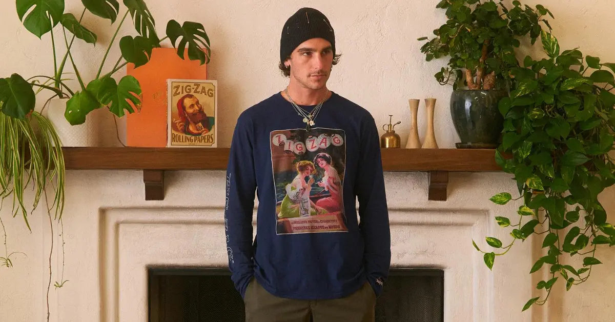 Zig-Zag long-sleeve shirt featuring vintage artwork modeled in a living room with plants and decor