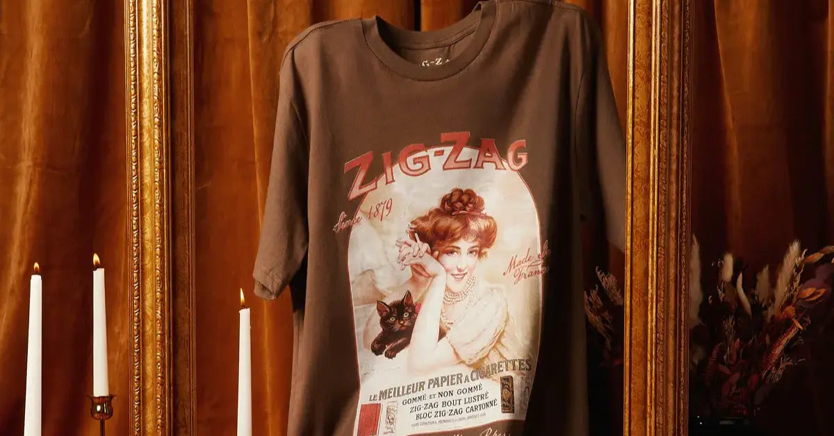 Zig-Zag T-shirt in brown featuring vintage artwork of a woman holding a black cat, displayed against a warm background.