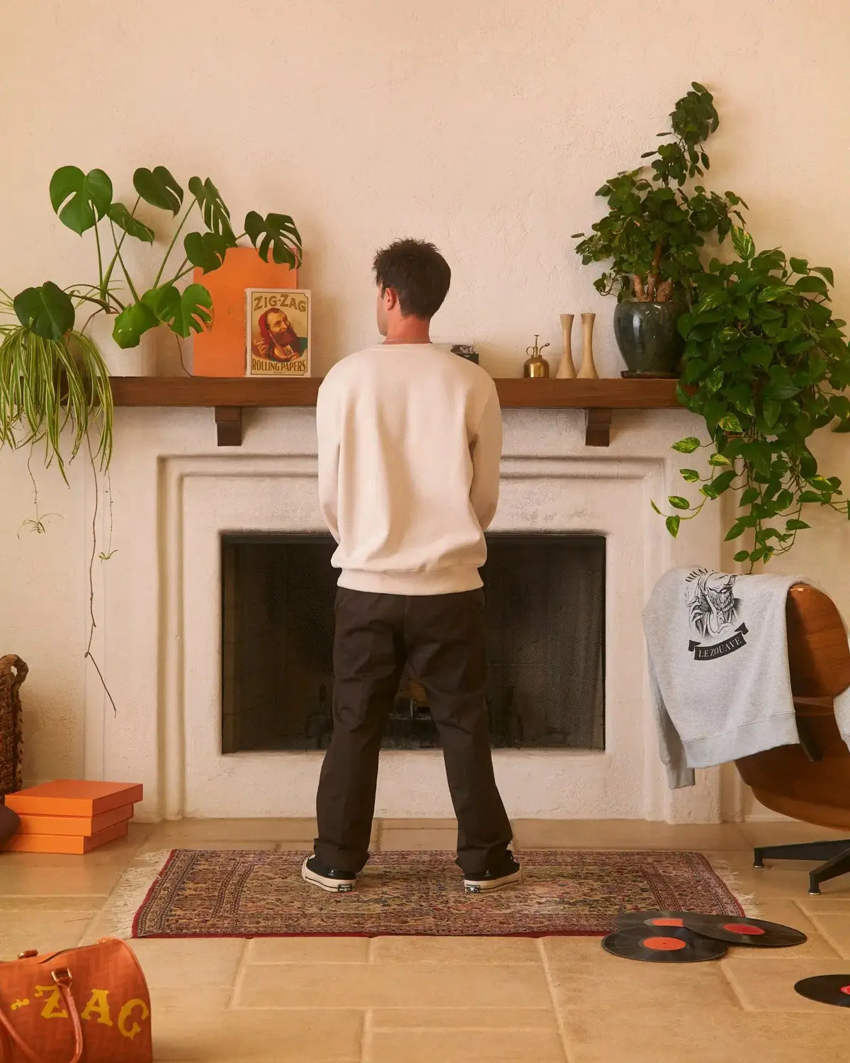 Zig-Zag crew neck sweatshirt worn by a person standing in a stylish room with plants, records, and branded decor.