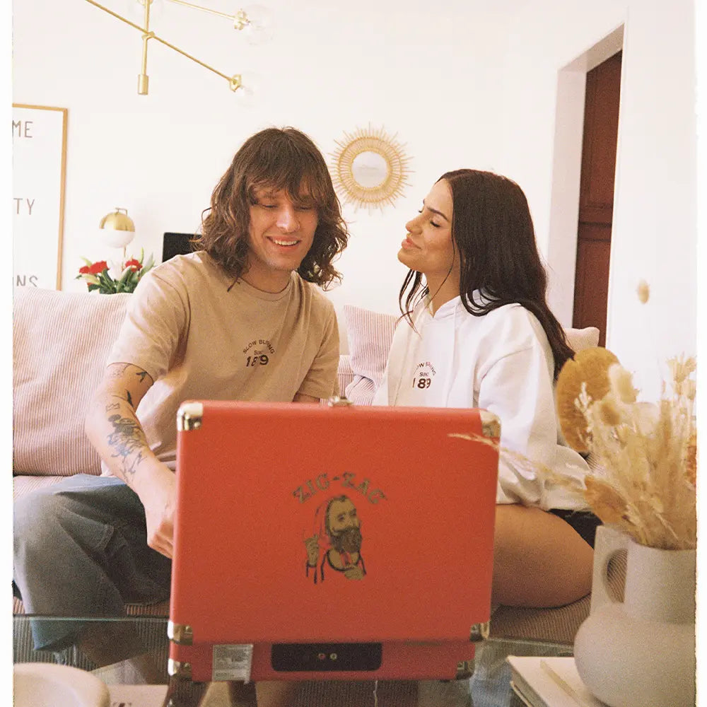 Zig Zag shirts worn by two people, featuring “Slow Burning Since 1879” text with casual vintage-inspired styling.