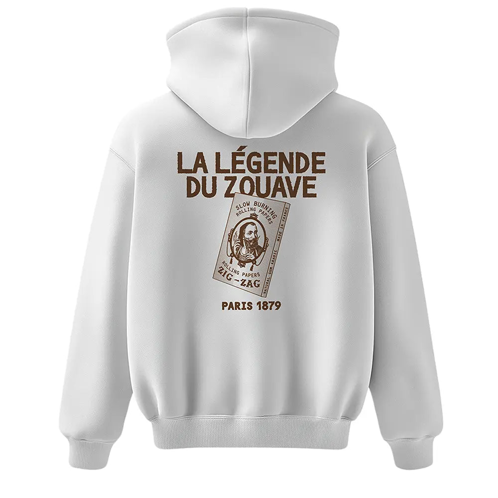 Zig Zag hoodie in white featuring vintage rolling paper artwork and bold brown French text reading “La Légende du Zouave.”