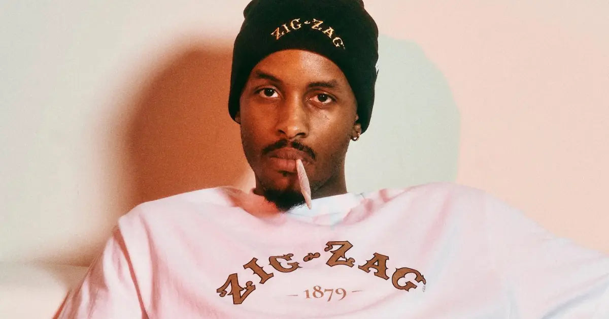 Zig-Zag beanie and white 1879 t-shirt with logo styled by a man holding a rolled paper