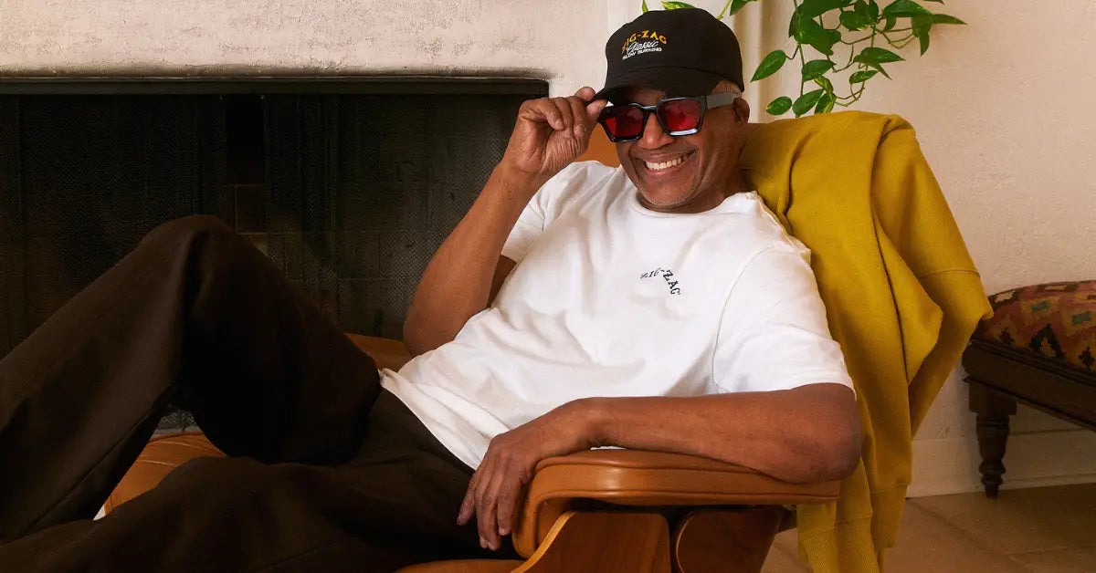 Zig-Zag logo t-shirt and cap worn by a smiling man relaxing in a chair indoors