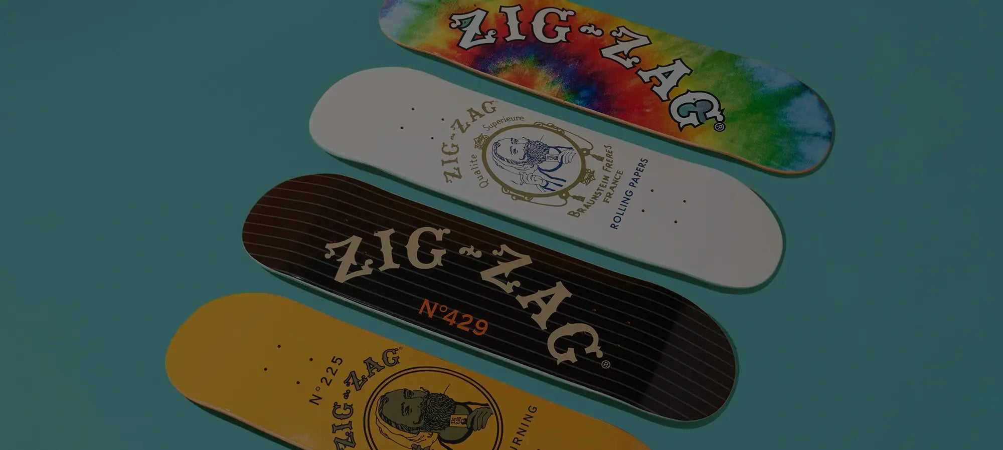 Zig-Zag skateboard decks in various designs and colors arranged on a blue background.